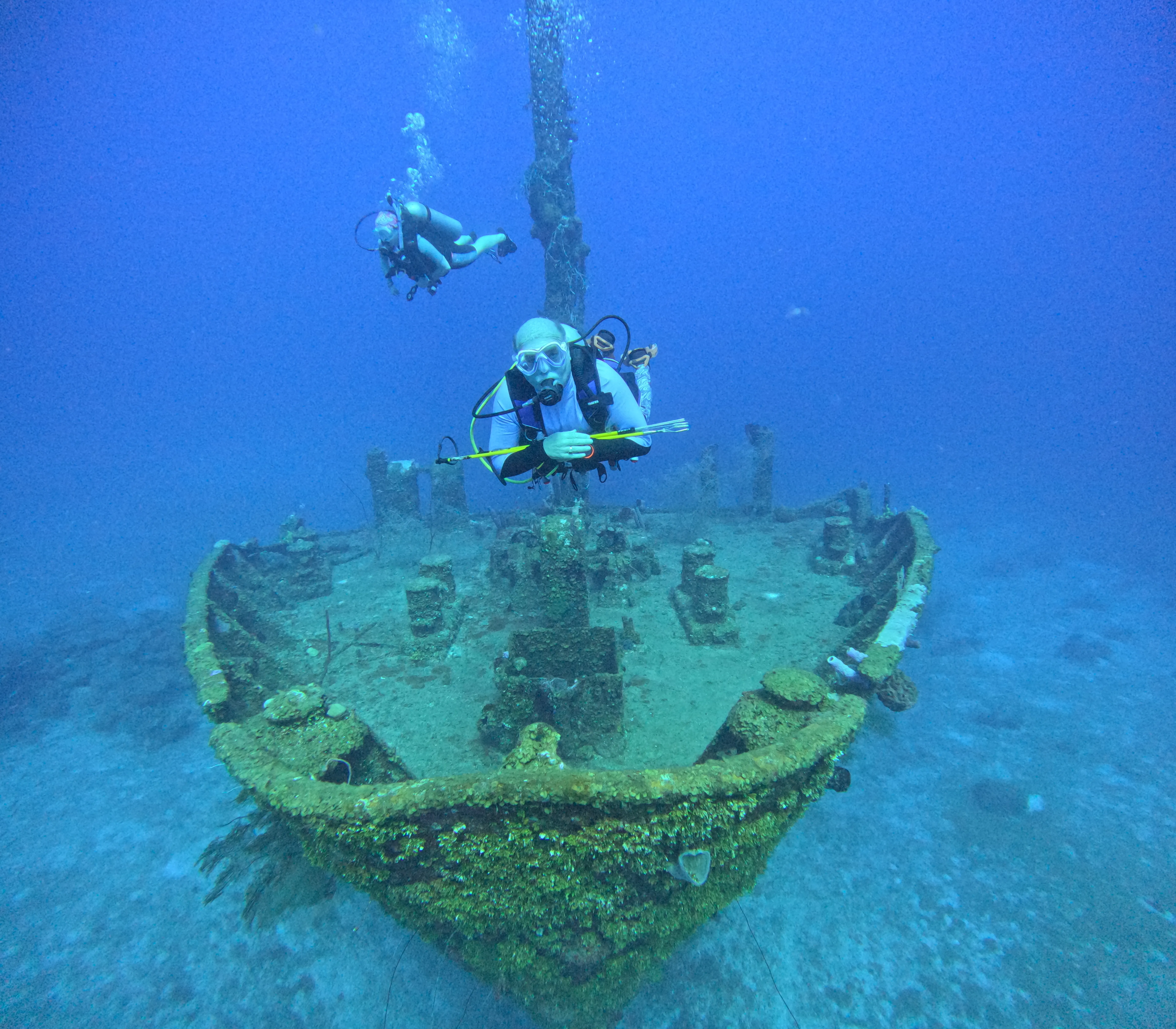 A diver approaching a shipwreck on the seabed