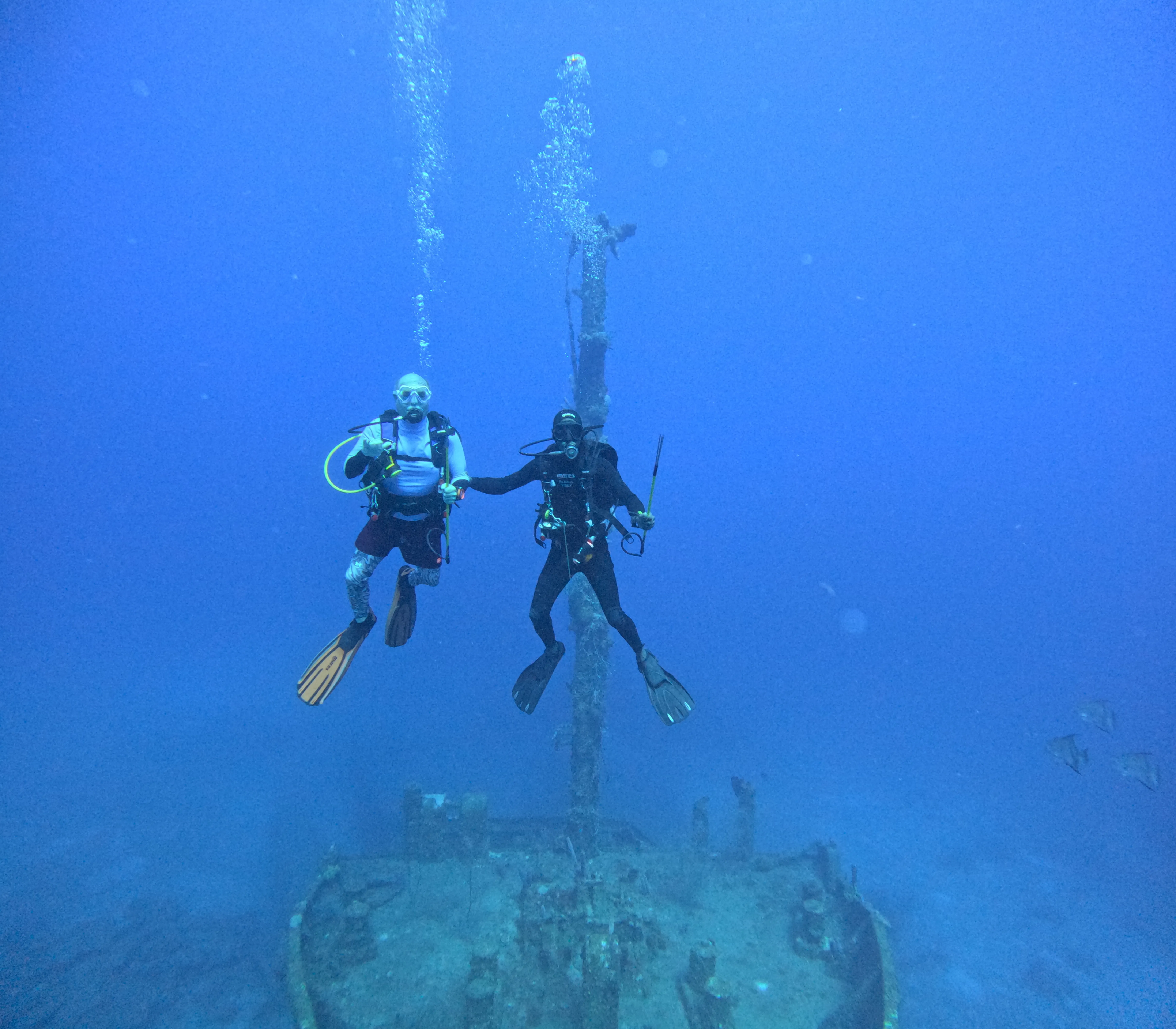 Two divers suspended in clear blue water